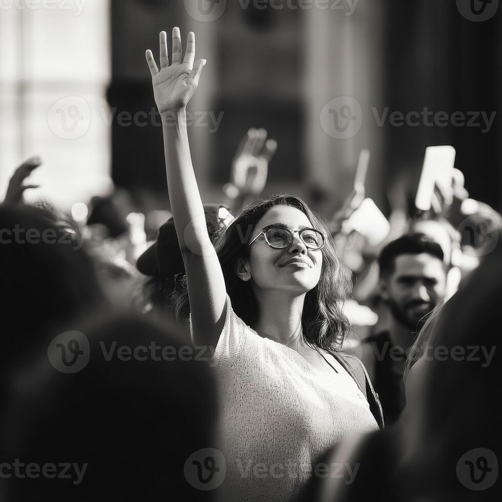 Crowd gathers in support, raising hands in solidarity during an afternoon event in a bustling urban location photo