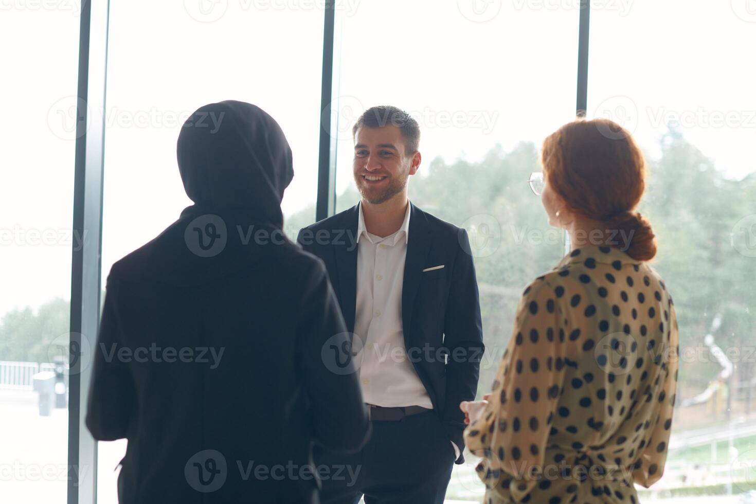 A business team engages in a lively discussion during a coffee break, exchanging challenges and sharing moments of laughter, fostering a positive and collaborative work environment photo