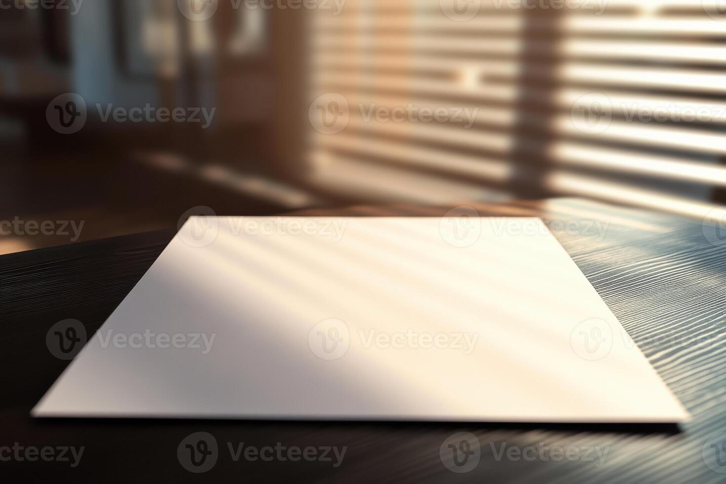 Empty white paper on wooden table in artistic sunlight through window blinds photo
