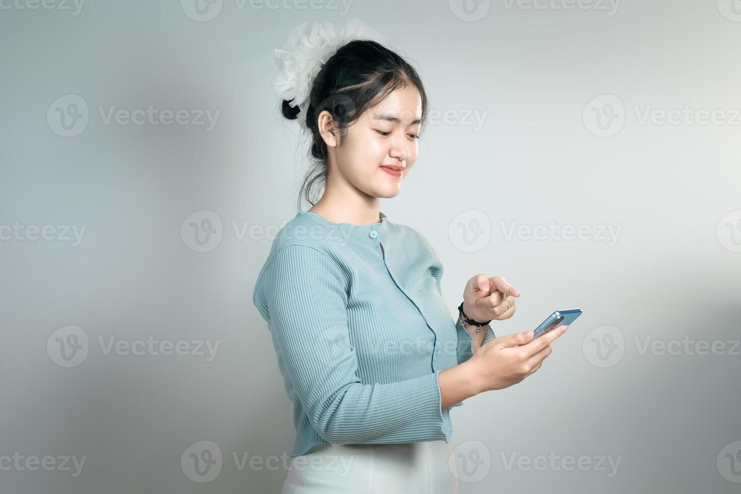 An excited young woman pointing her smartphone in her hand photo
