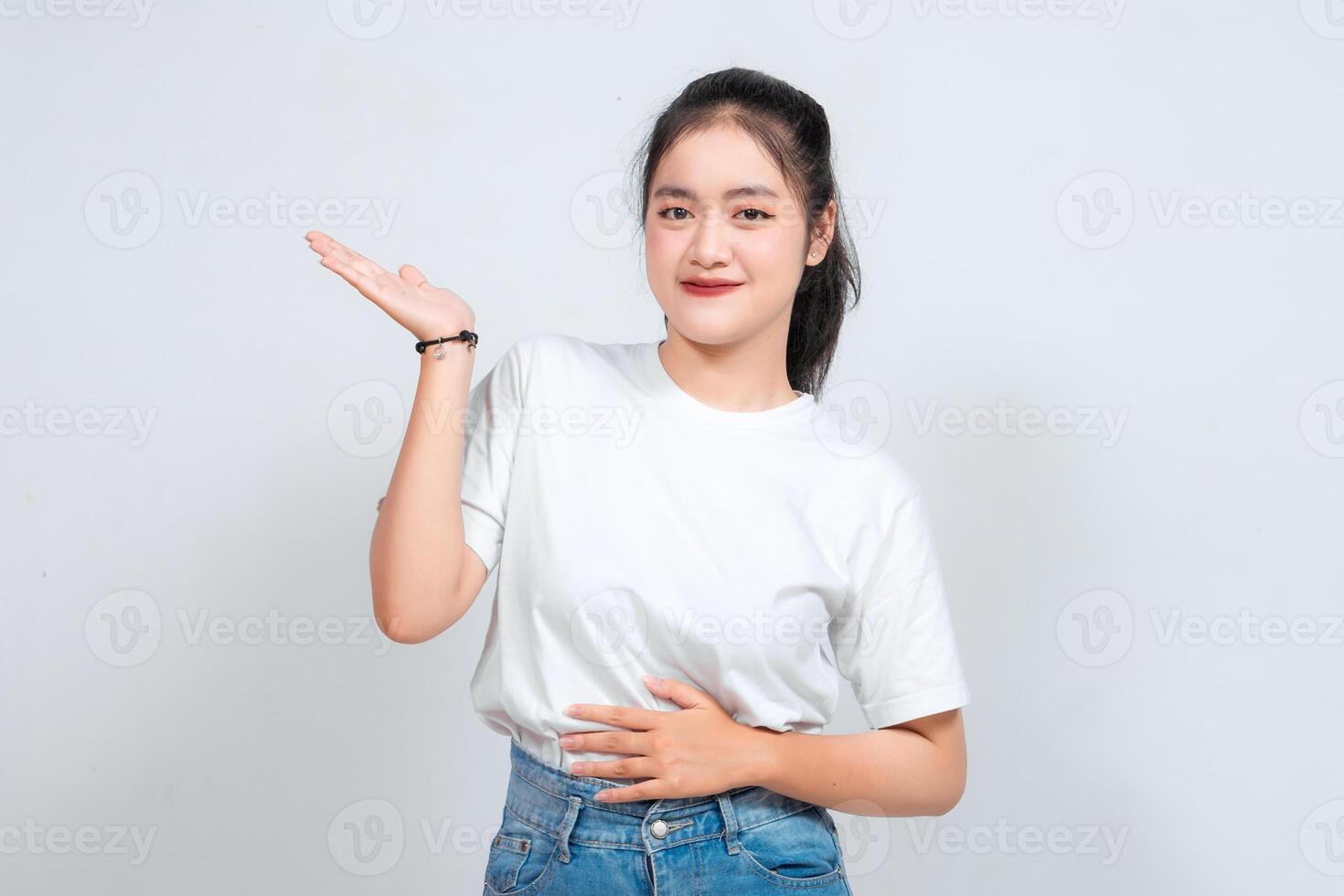 An Asian woman smiles and waves with both hands against a white background. photo