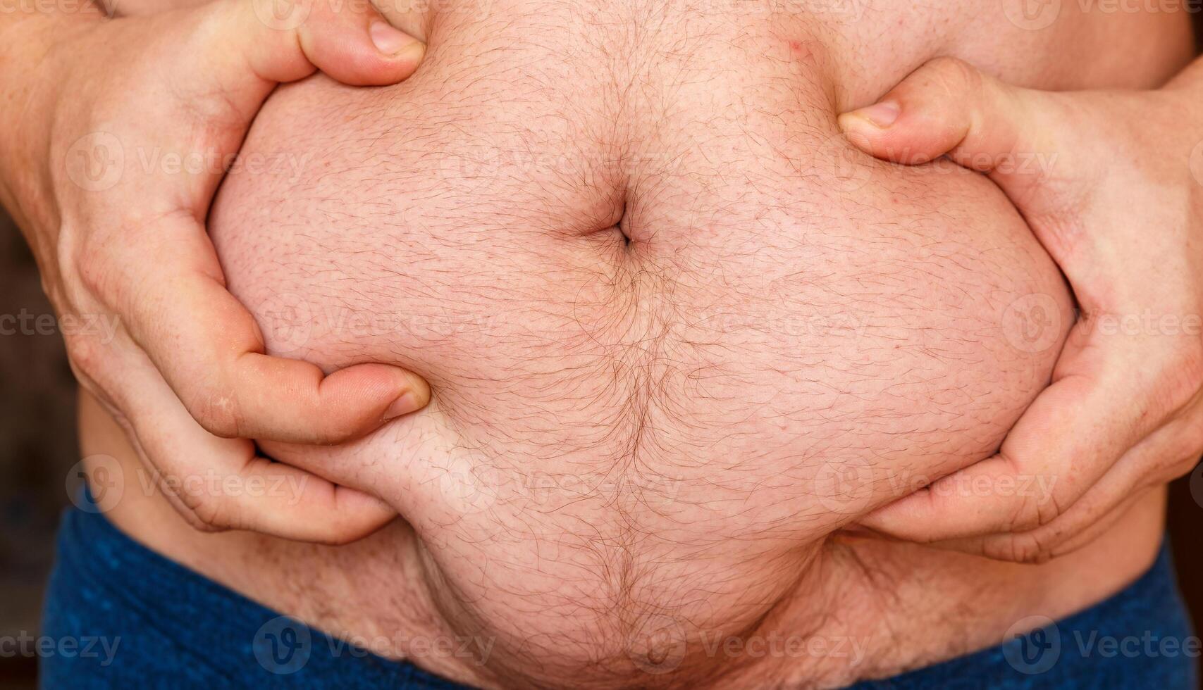 Man showing his fat on stomach. photo
