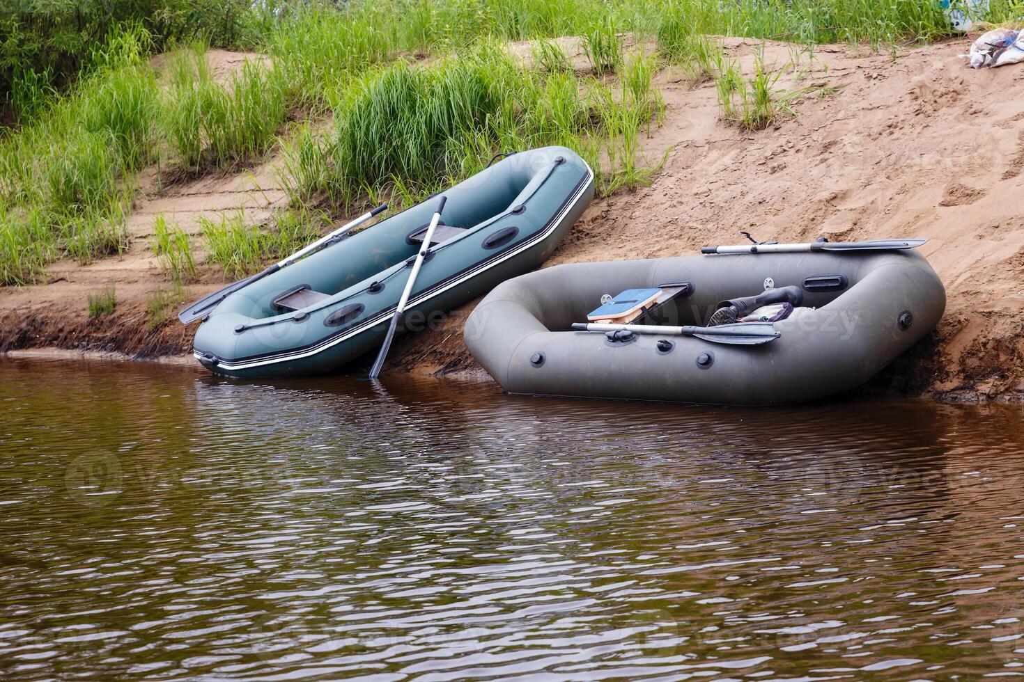 two rubber boats, two rubber boats on coast river. photo