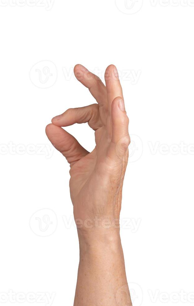 Pinch gesture. Elderly woman s wrinkled hand holding something tiny between thumb and forefinger, photo