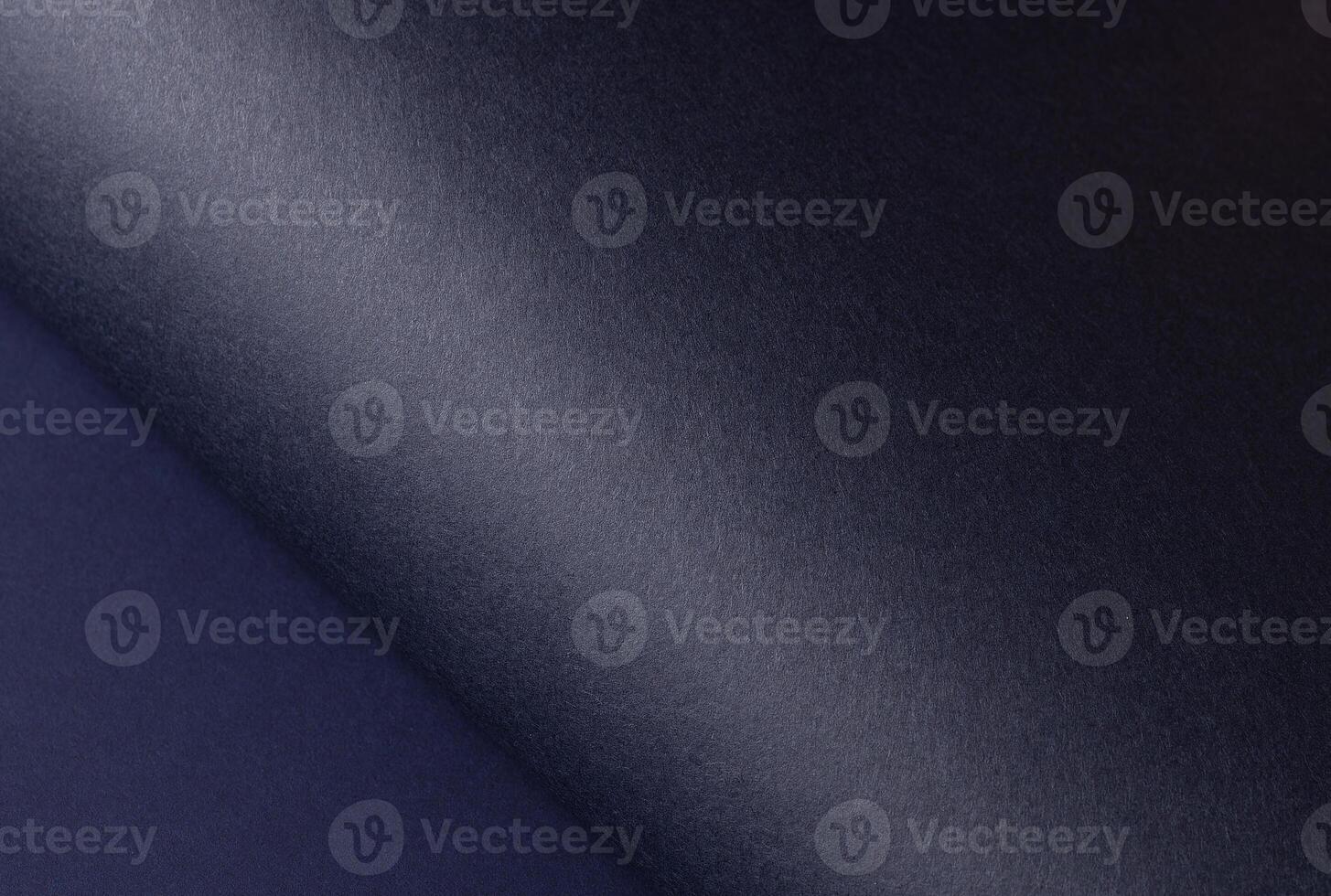 Midnight blue paper background with a curved, gradient matte surface and a smooth, grainy texture. photo
