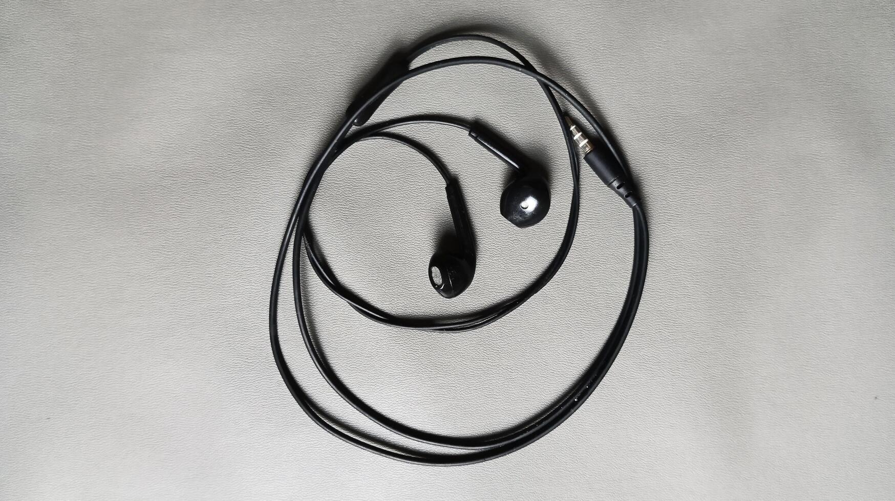 Black earphones isolated on a gray background photo