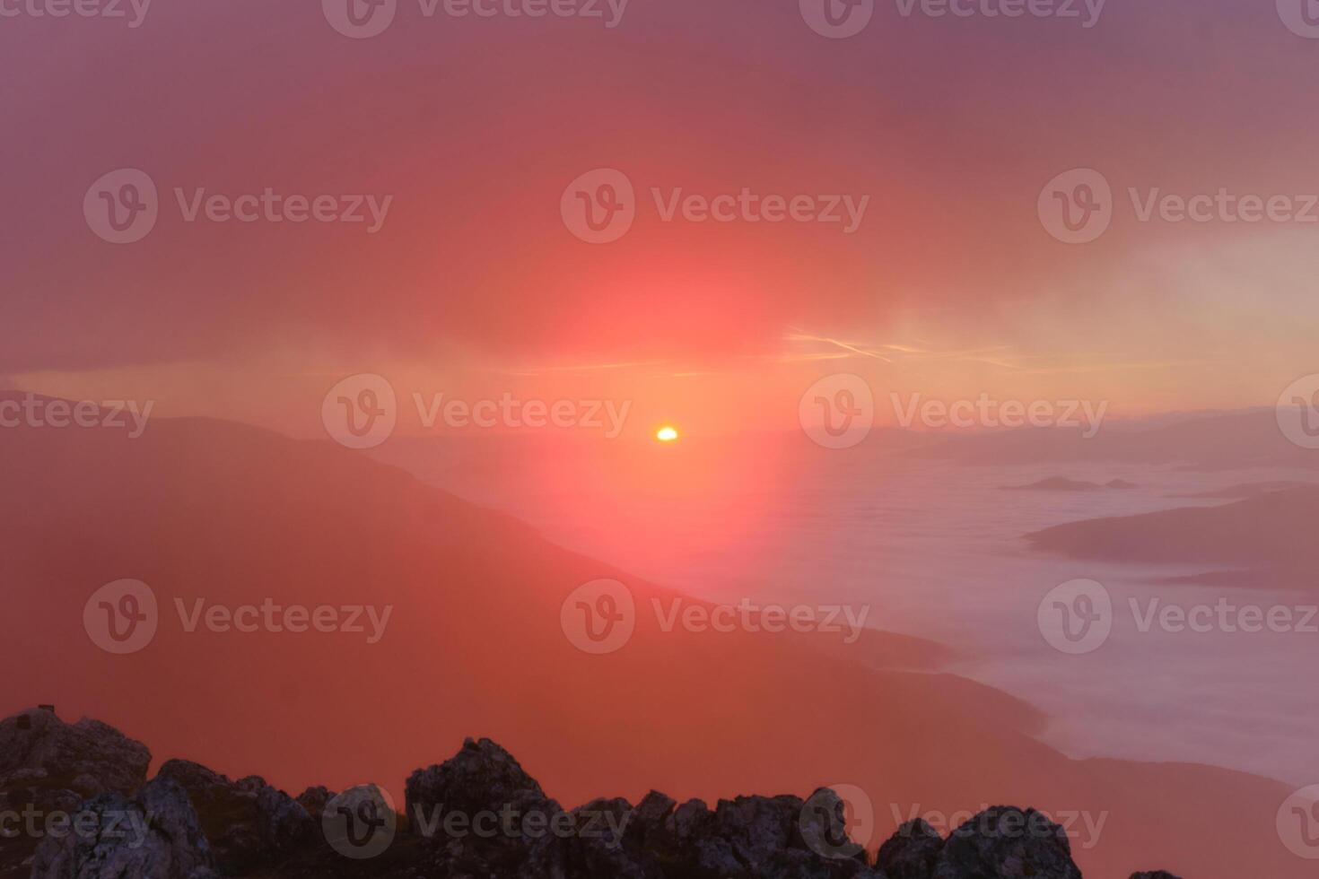 The landscape view of the foggy mountain at sunrise or sunset nature background. photo