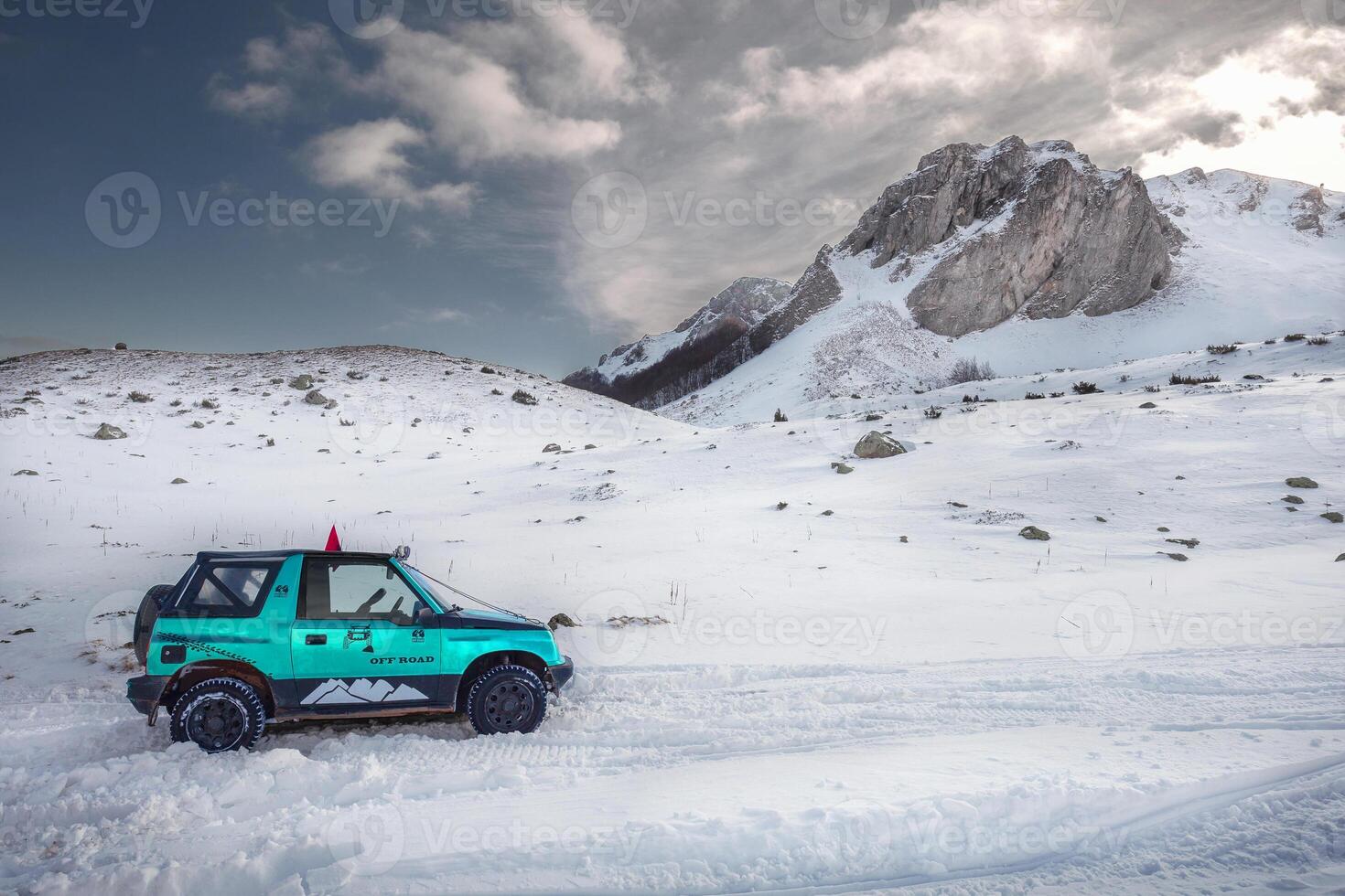 4x4 Off-road car adventure travel on the snowy mountain in winter. photo