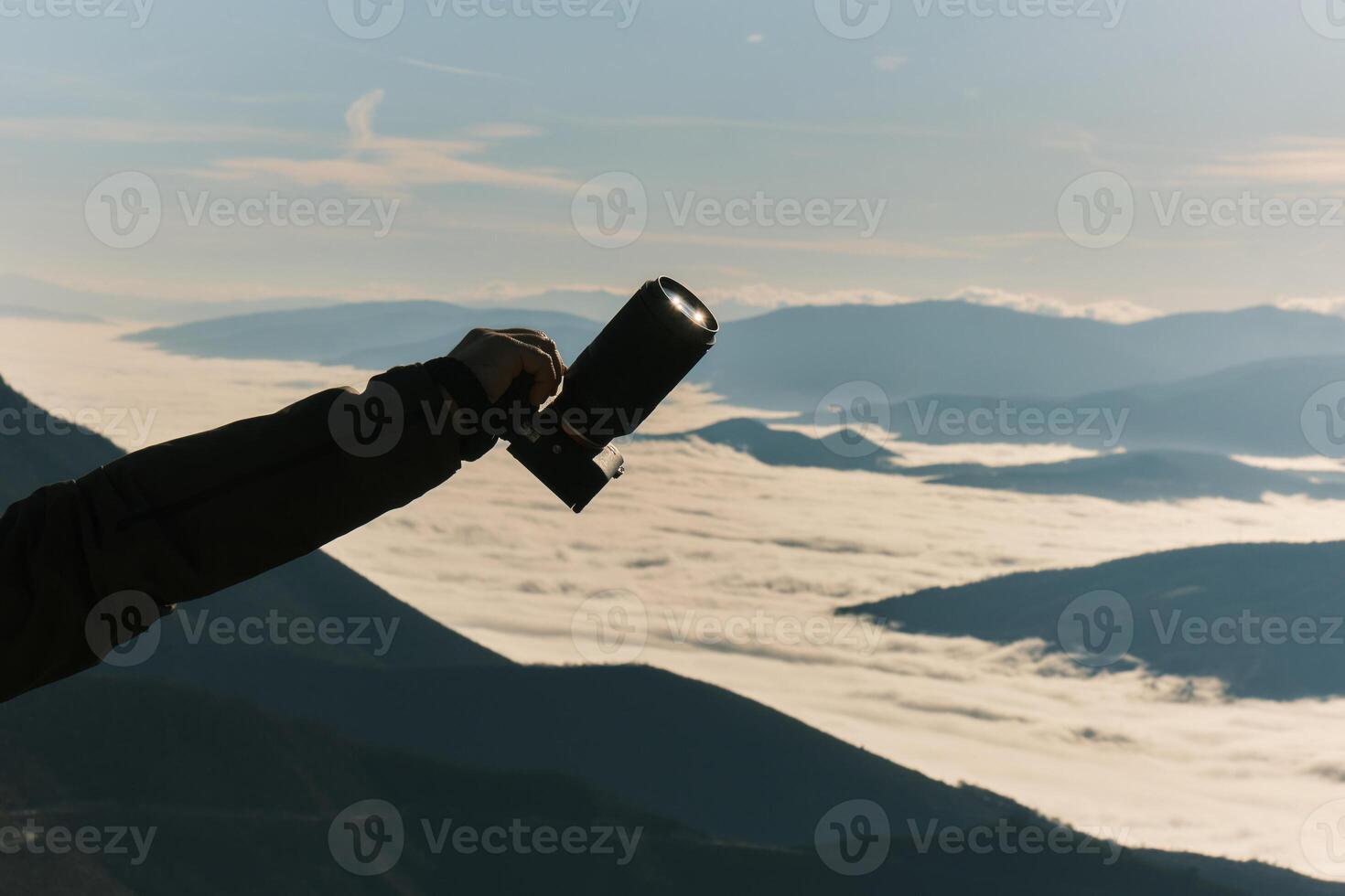 Male hand holding dslr camera against nature background travel photography. photo