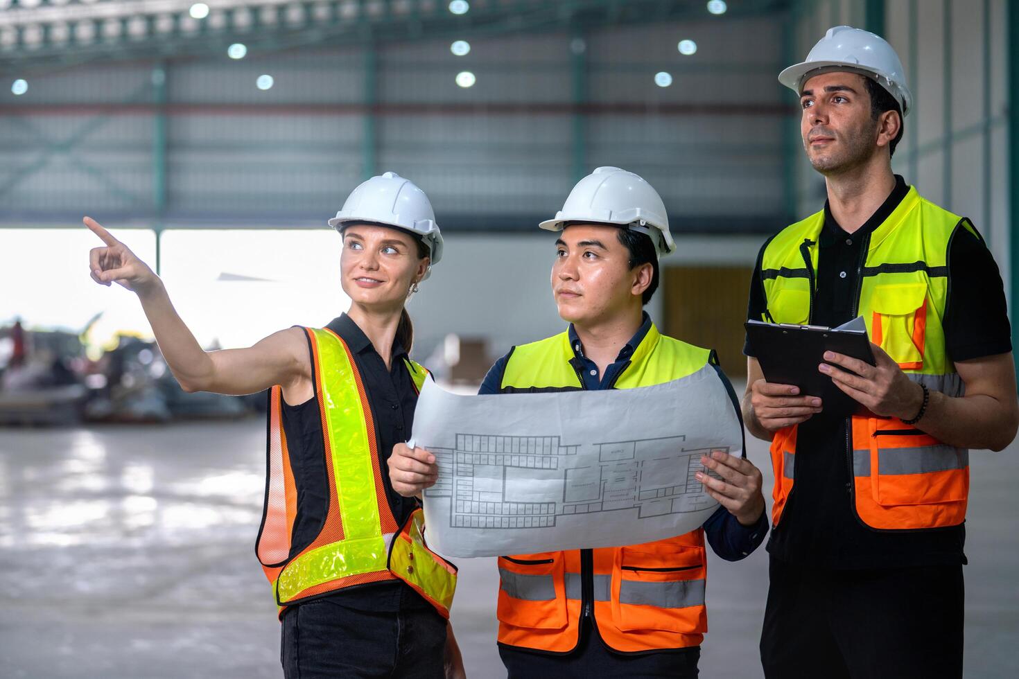 Three construction workers are standing in a large building photo