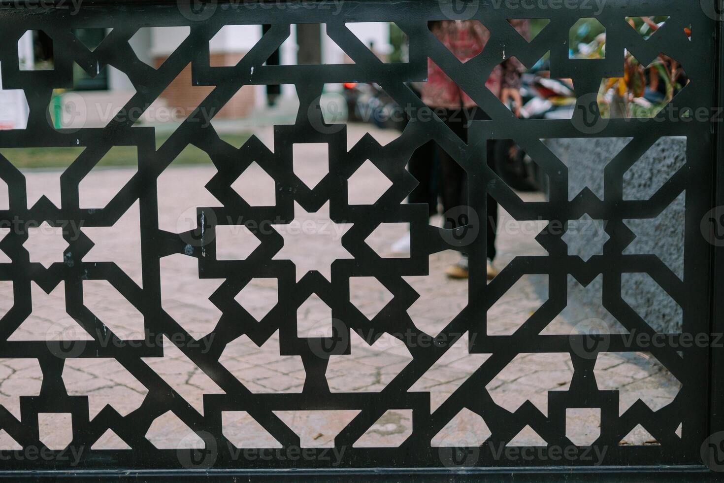 Geometric black metal lattice showcasing intricate Islamic design in an urban setting. so nice photo