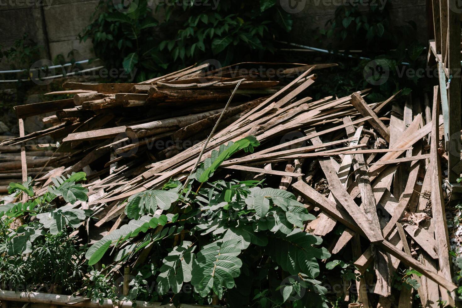Pile of used wooden planks and beams, showing weathered textures and signs of previous usage, photo