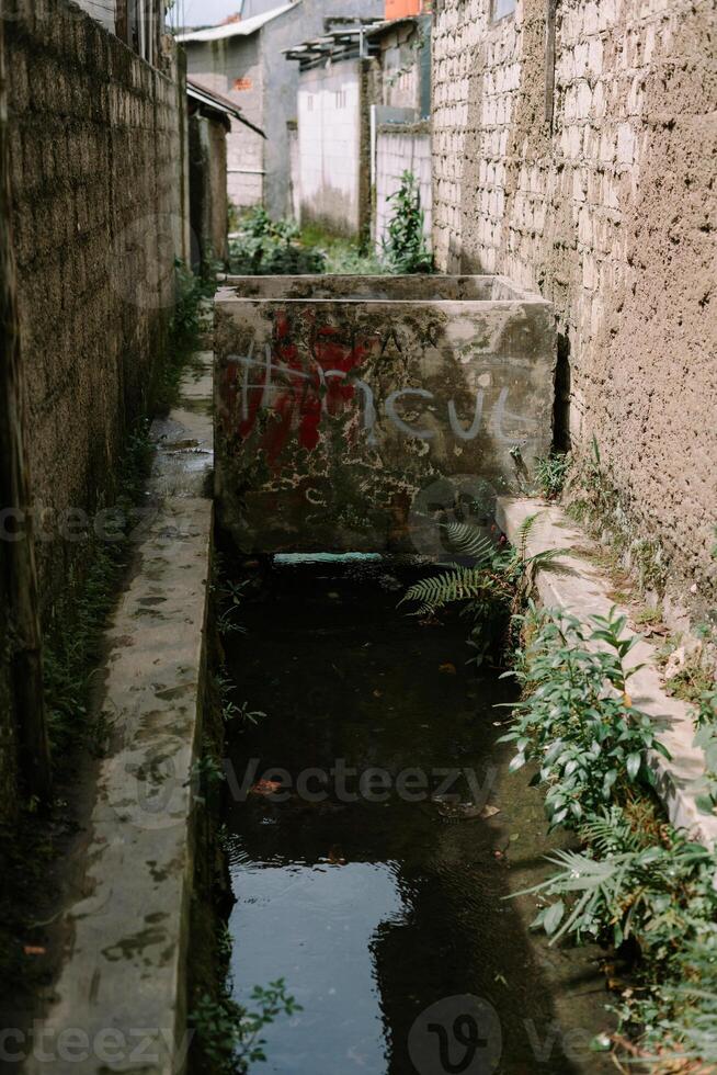 A small waterway flows through a narrow alley photo