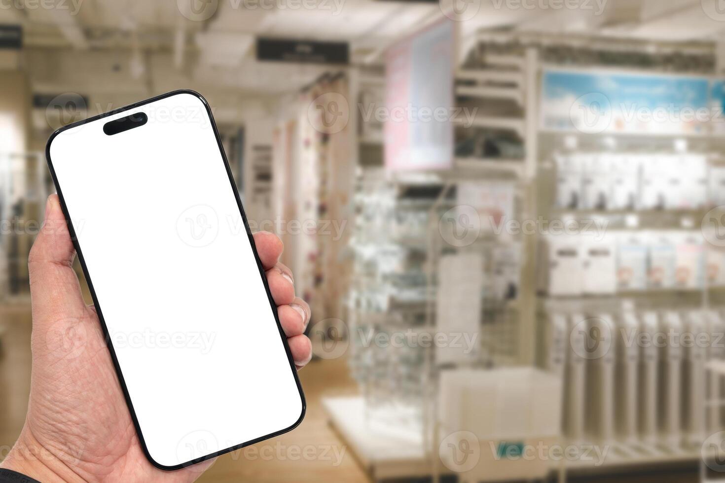 e for app or web site mockup. Smart phone with white screen in hand on Blur furniture store background.Mockup blank screen mobile phon photo