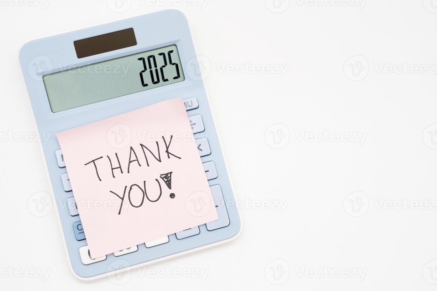 Hand writing THANK YOU on pink sticky note on light blue calculator in isolated background and Copy space. 2025 Calculator. photo