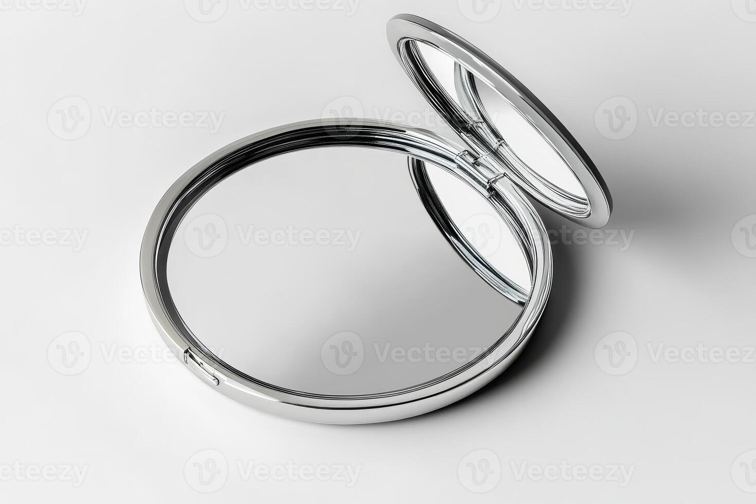 A silver mirror is opened and has a reflection of itself photo