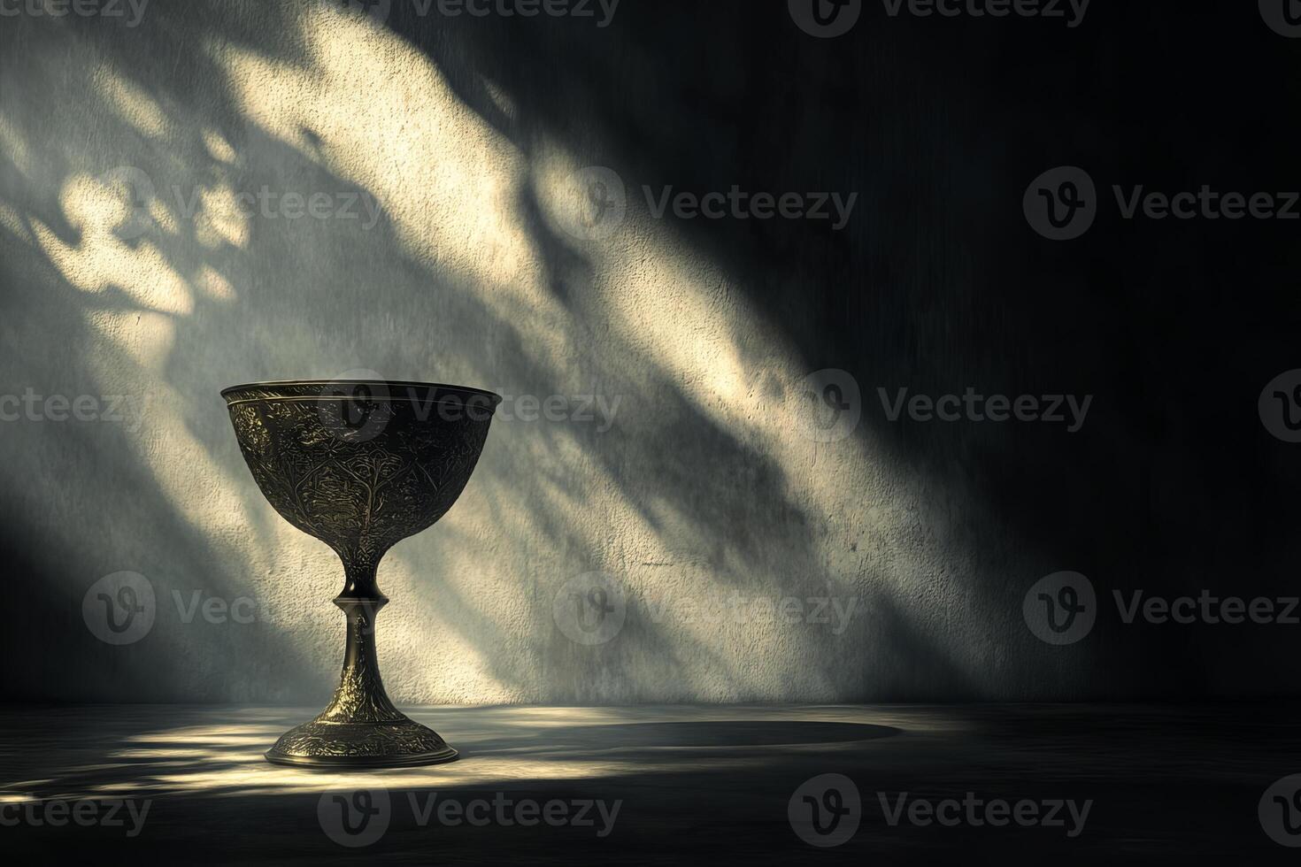 A small, ornate cup sits on a table in a dimly lit room photo