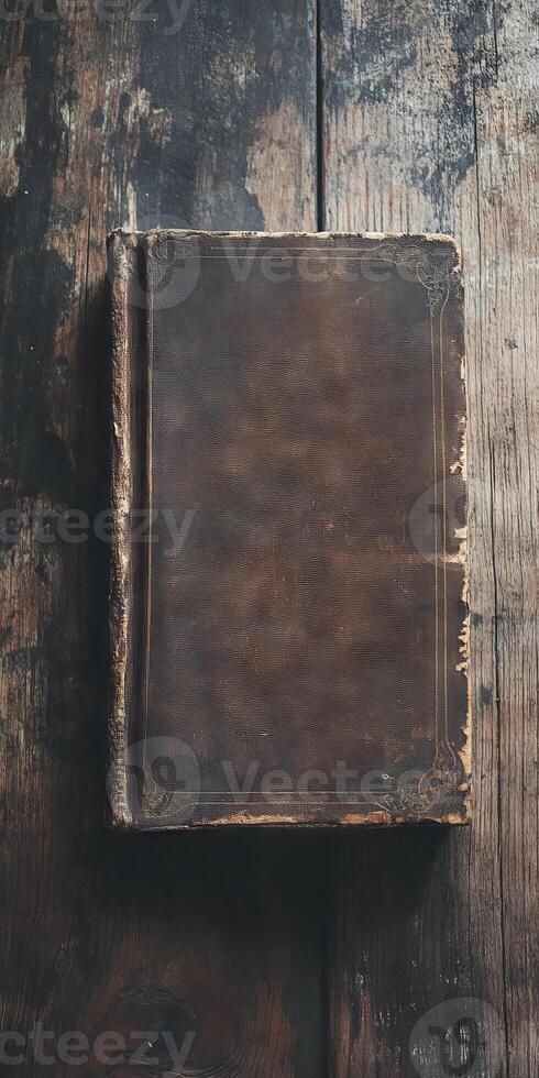 A book with a brown cover sits on a wooden table photo