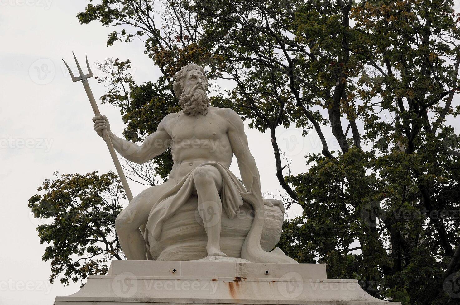 A statue of a man holding a trident in copenhagen photo