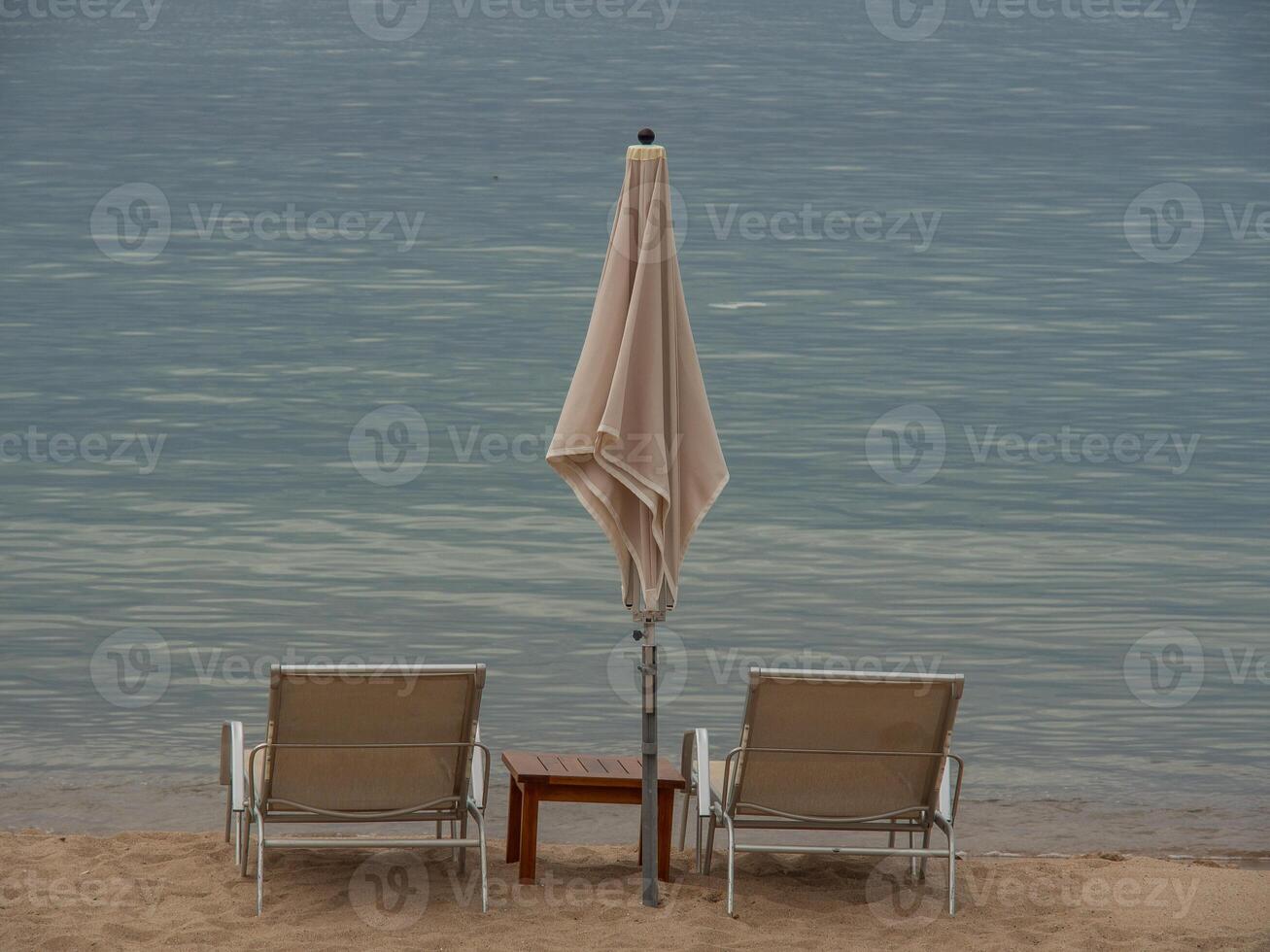 Two chairs and an umbrella on the beach photo