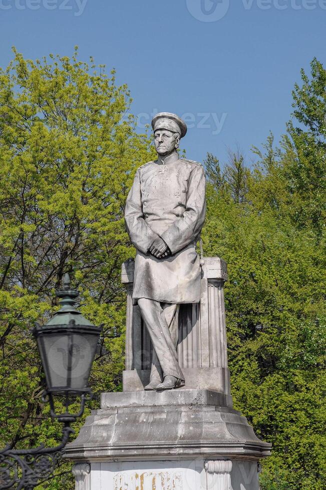 A statue of a man sitting on a stone monument photo