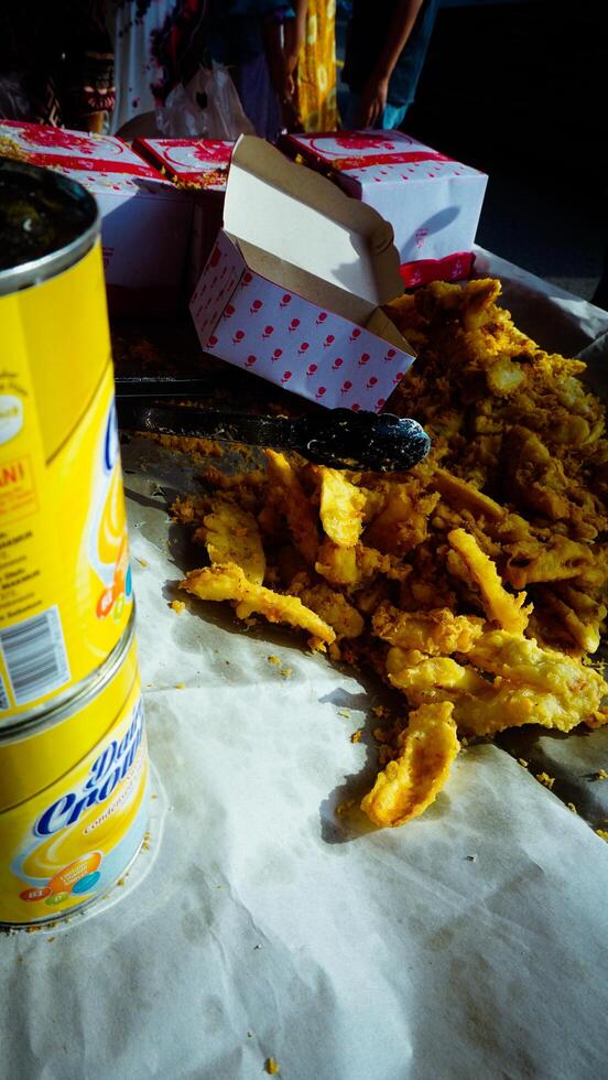 Crispy Fried Snacks on Paper with Can and Box photo