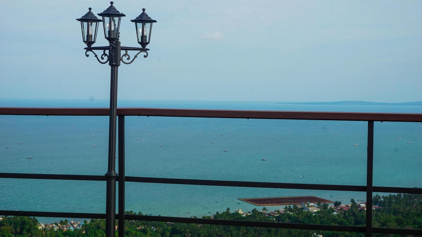 Scenic Ocean View from a Balcony with Lamp Post photo