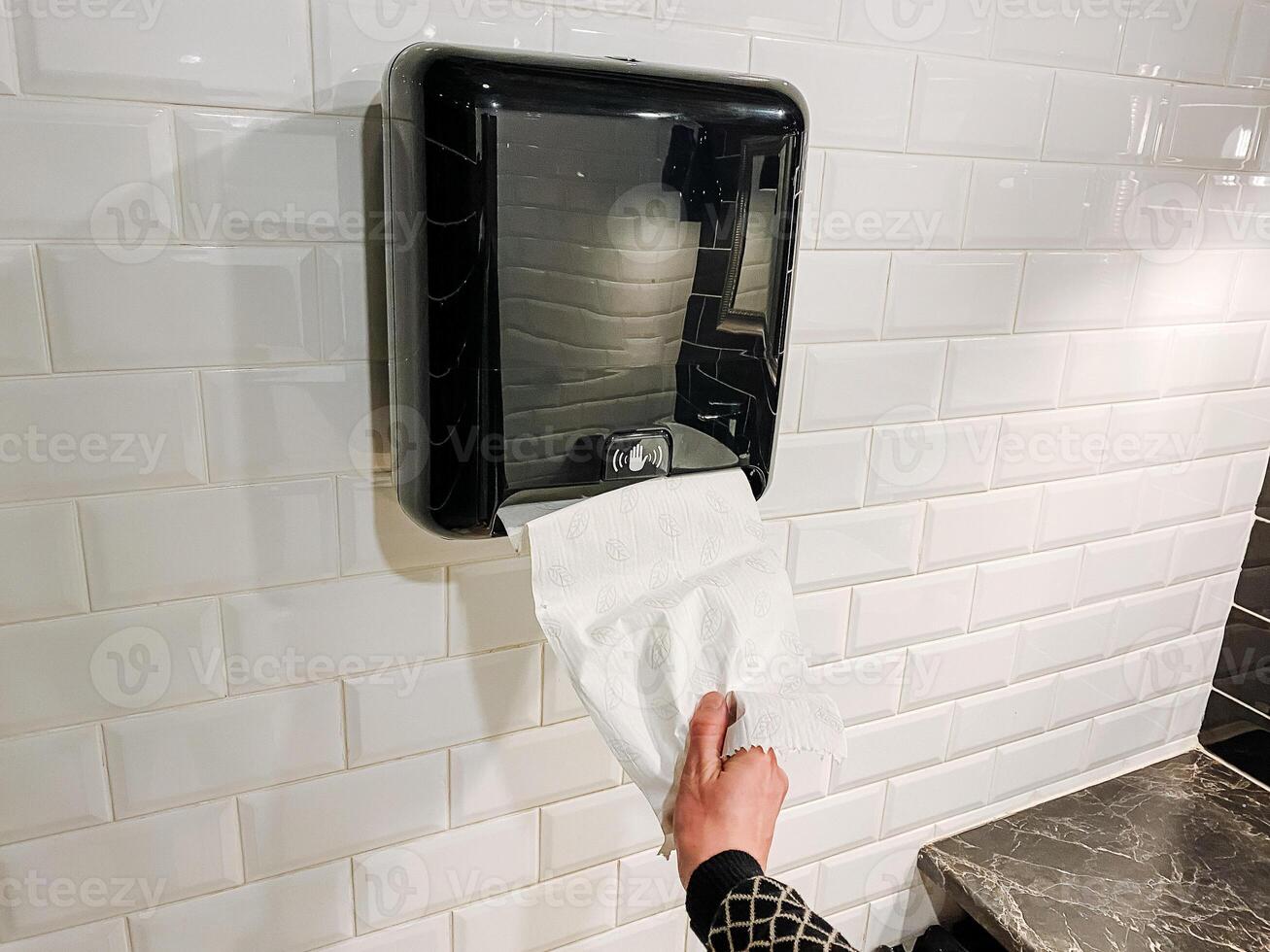 Building occupants making use of paper towel dispenser in room photo