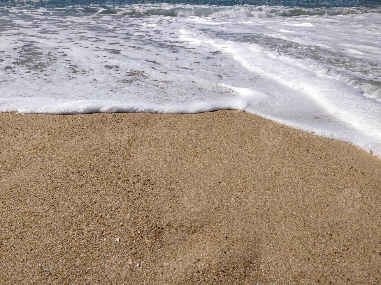 Serene beach scene foamy waves gently lapping golden sand. Perfect for travel, nature, or summer themes photo