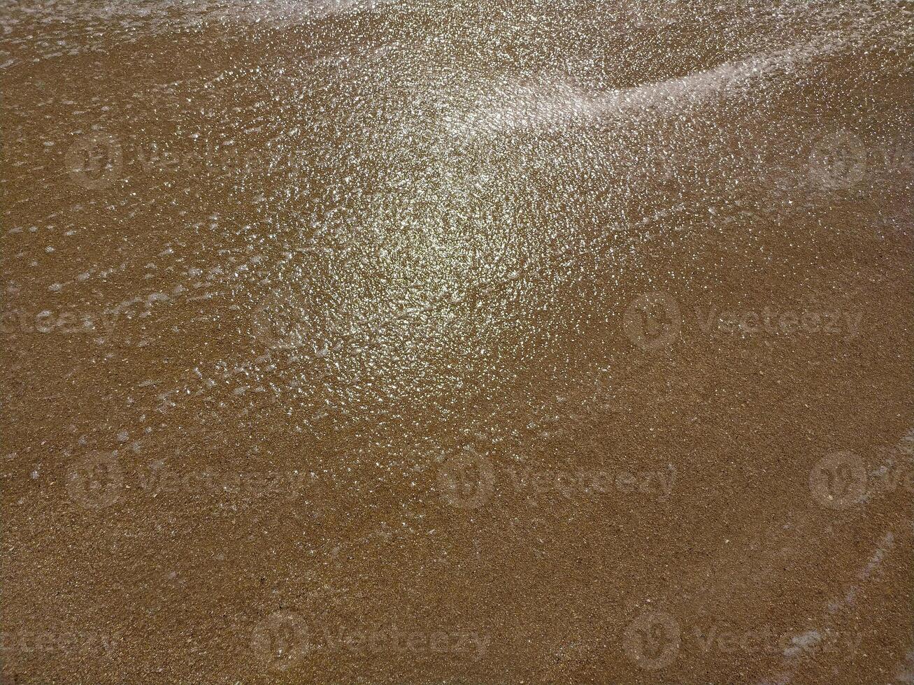 Fine golden sand covering a beach during a suns, creating a serene and tranquil atmosphere for relaxation photo