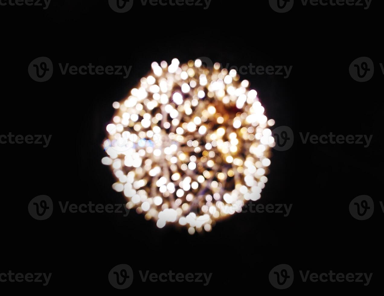 Abstract bokeh image of warm-toned lights creating a luminous circle against a black background. Perfect for holiday designs, celebratory themes, or adding a touch of magic to your projects. photo