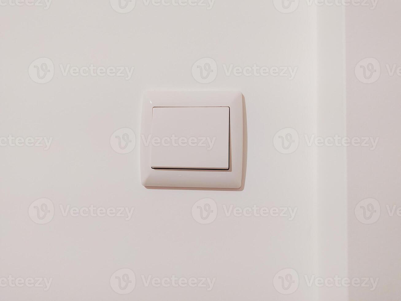 Clean, minimalist image of a single white light switch on a white wall. Perfect for interior design, home improvement, or minimalist lifestyle projects. photo