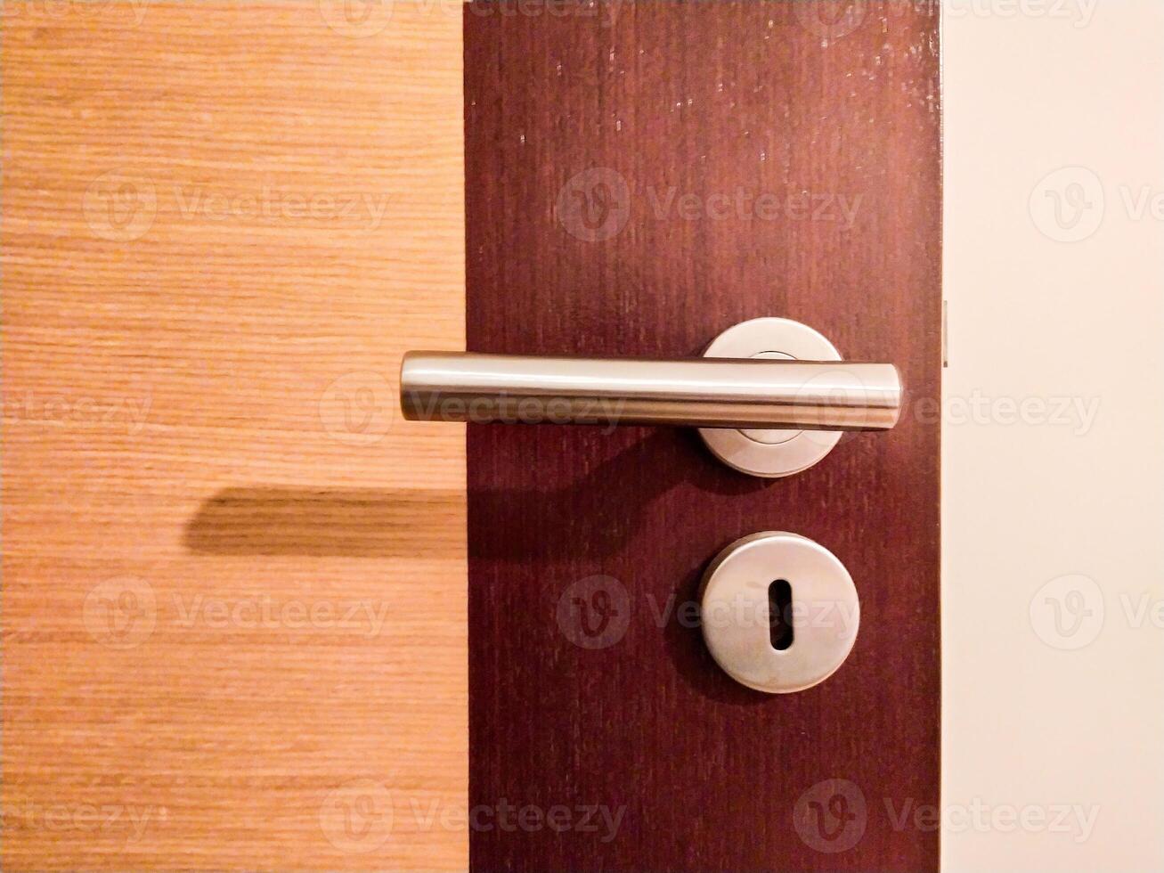 Modern door handle detail on a rich wood door. Clean lines, metallic accents, and a minimalist design. Perfect for architecture, interior design, and home improvement projects. photo