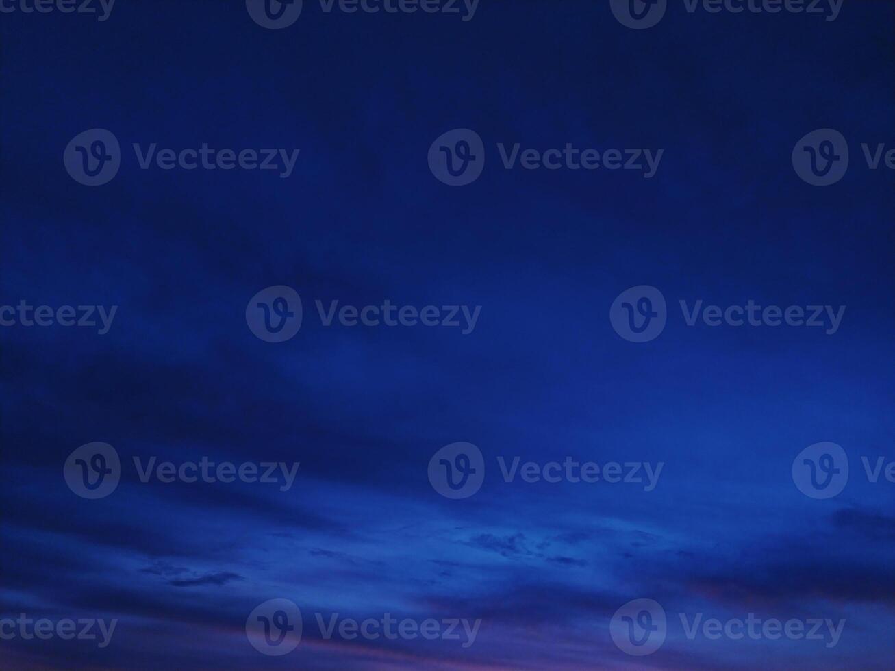 Stunning twilight sky, deep blue hues with subtle cloud formations. Perfect for backgrounds, website headers, or moodsetting visuals in design projects. Evokes serenity and mystery. photo