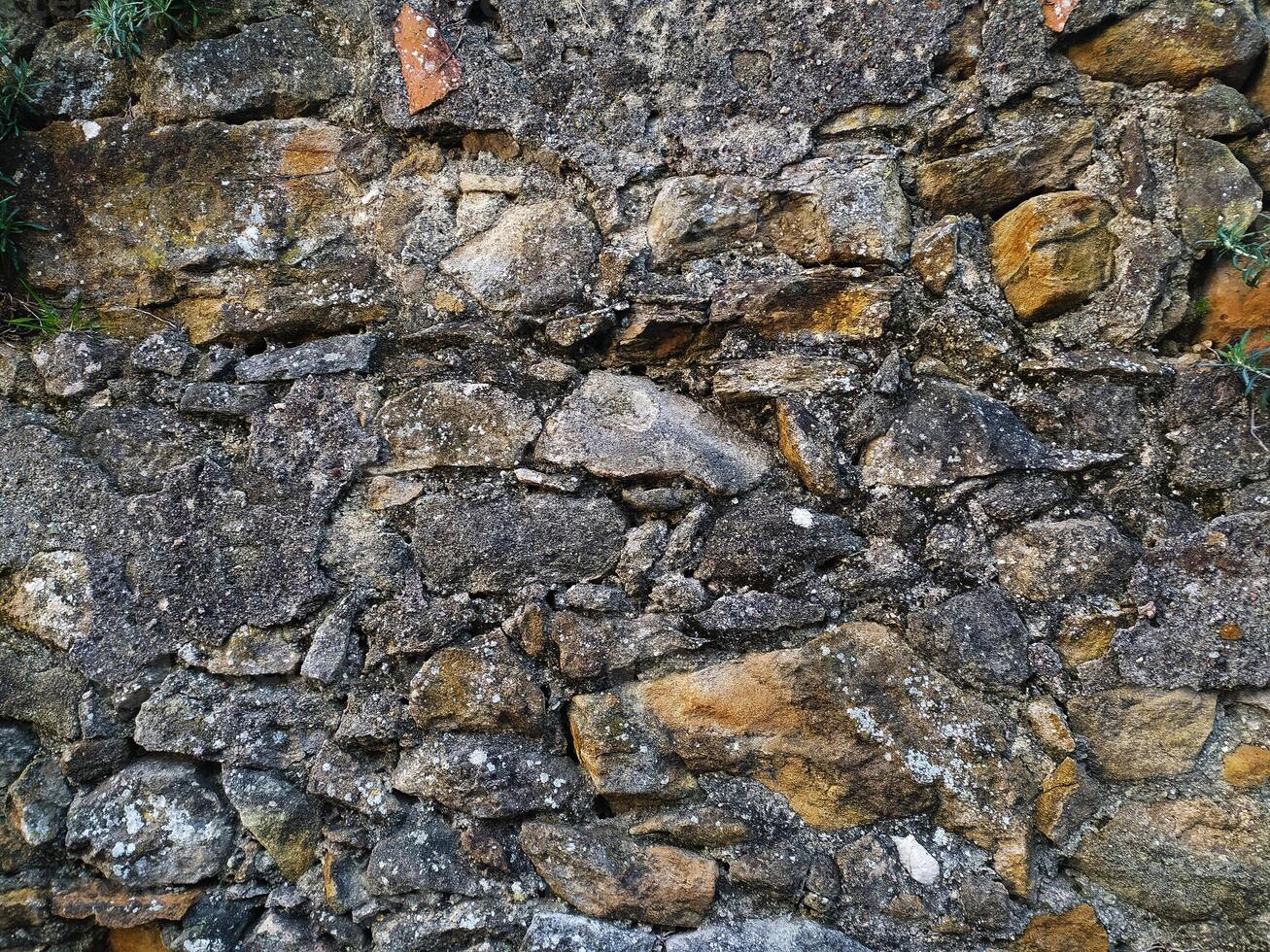 Rustic stone wall texture. Irregularly shaped stones in shades of gray and brown, set in mortar. Perfect for backgrounds, textures, or design projects needing a vintage, aged aesthetic. photo