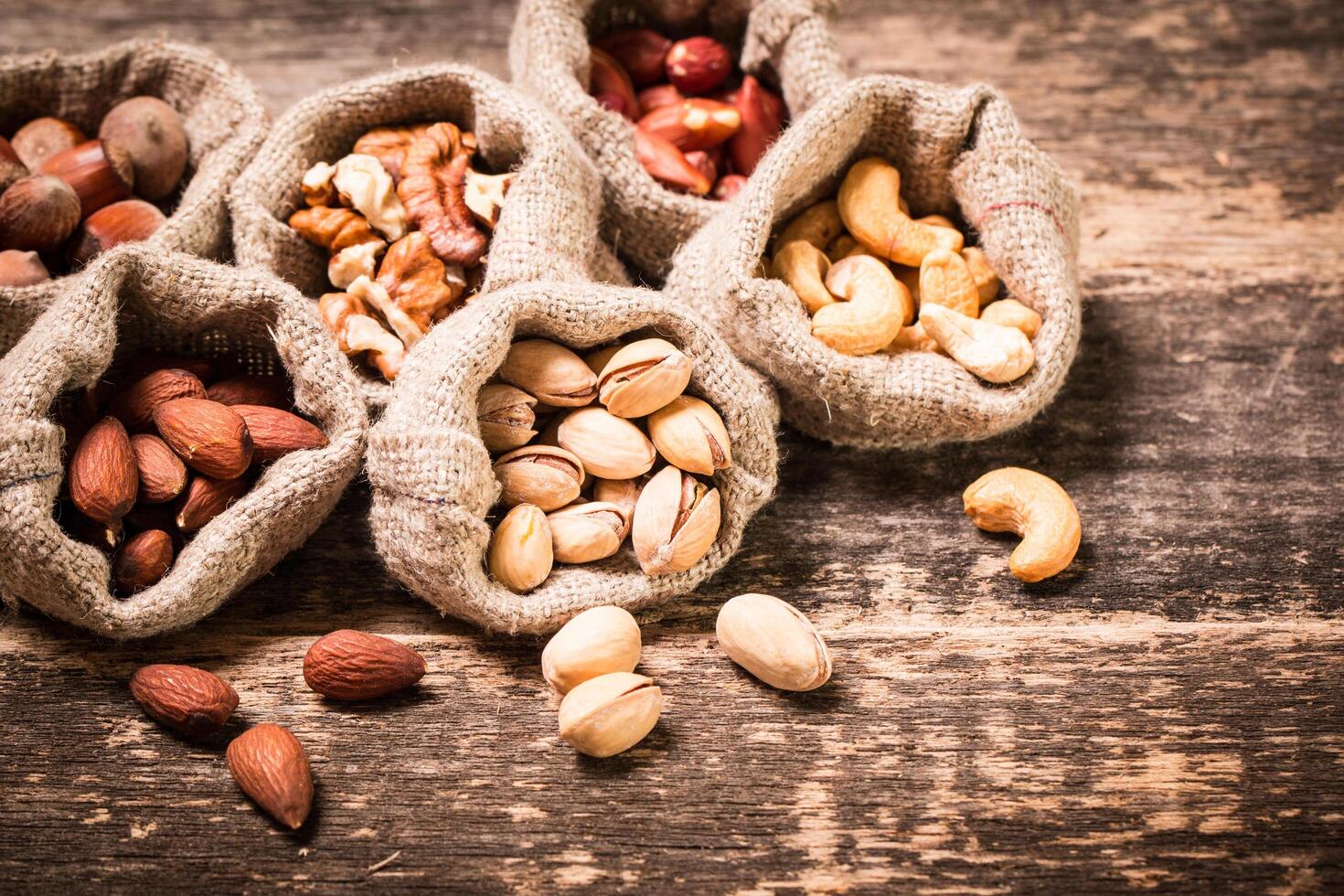 Nuts in bags on a wooden table photo