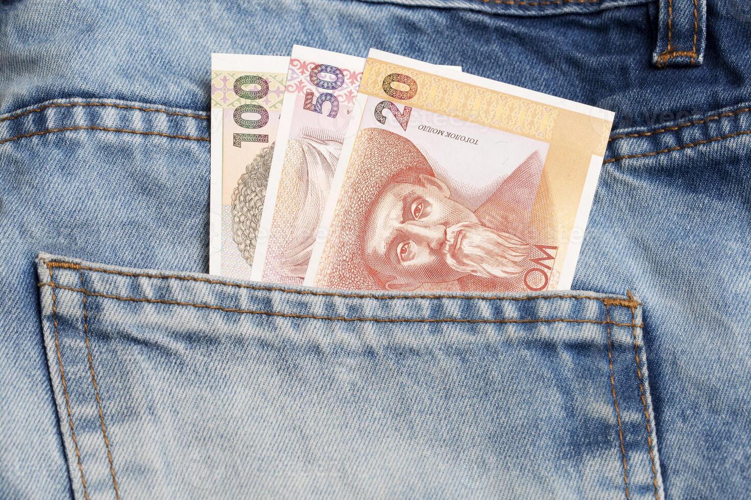 Old Kyrgyz money - som in the pocket of blue jeans a business background photo