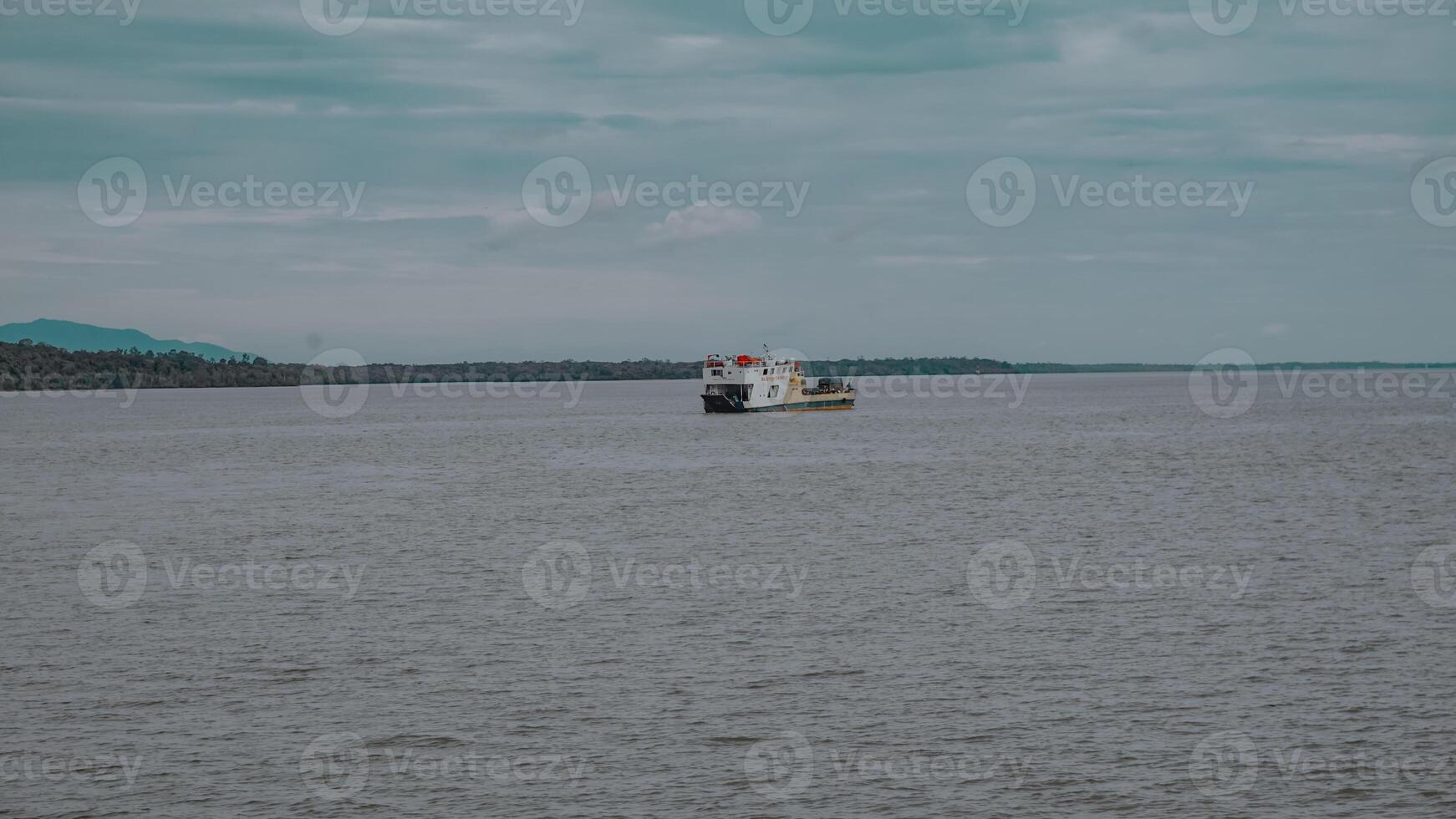Vessel Sailing on a Calm River Surrounded by a Scenic Landscape photo
