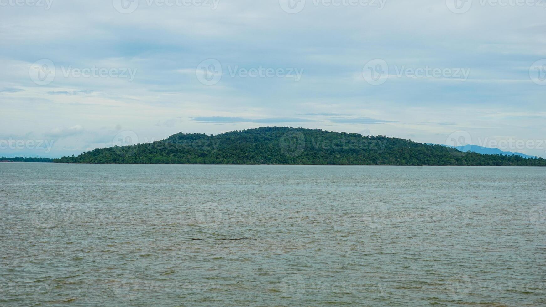 Scenic View of a Remote Island Surrounded by Calm Ocean Waters photo