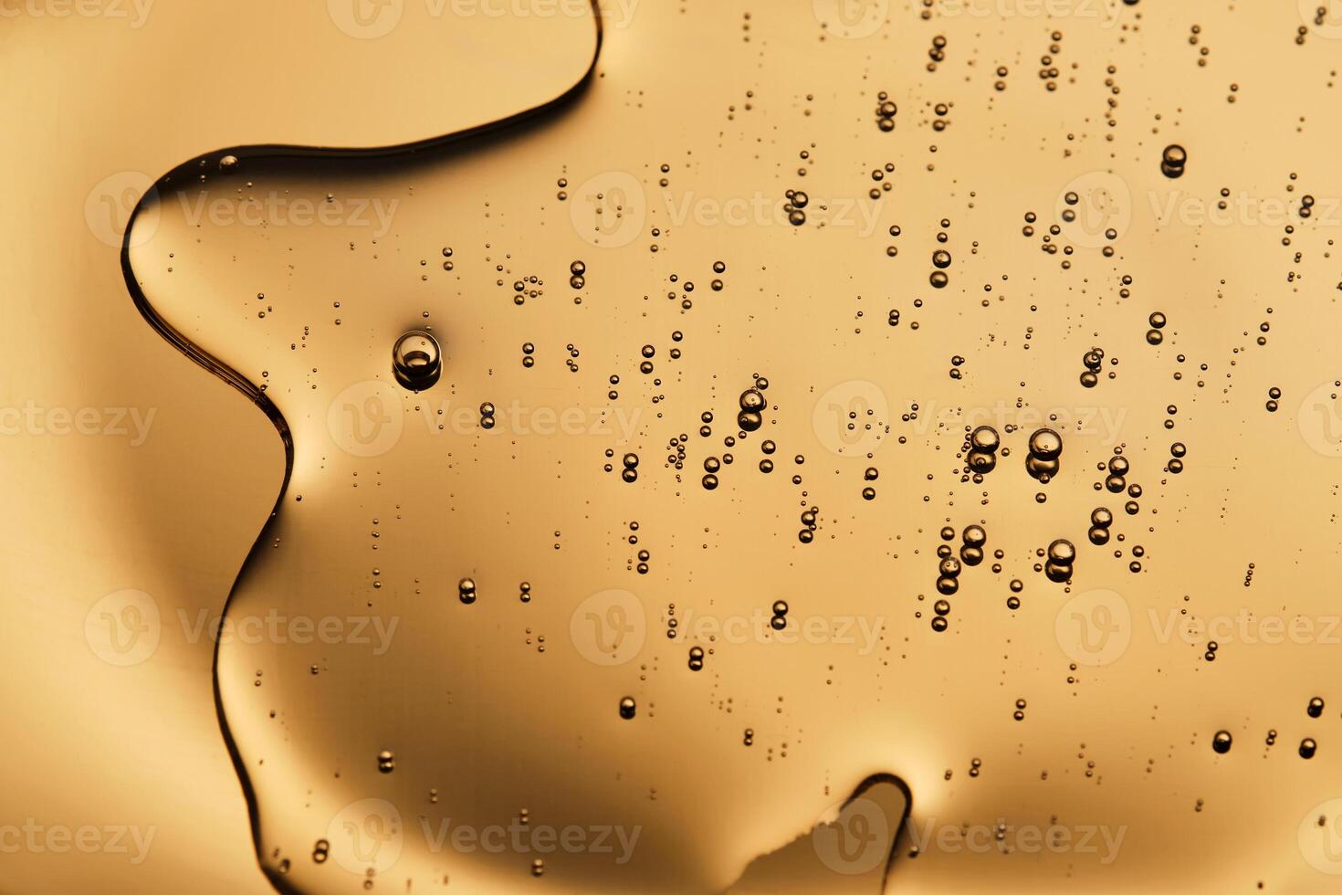 The beautiful texture of the cosmetic serum on a gold background that takes up most of the photo. photo