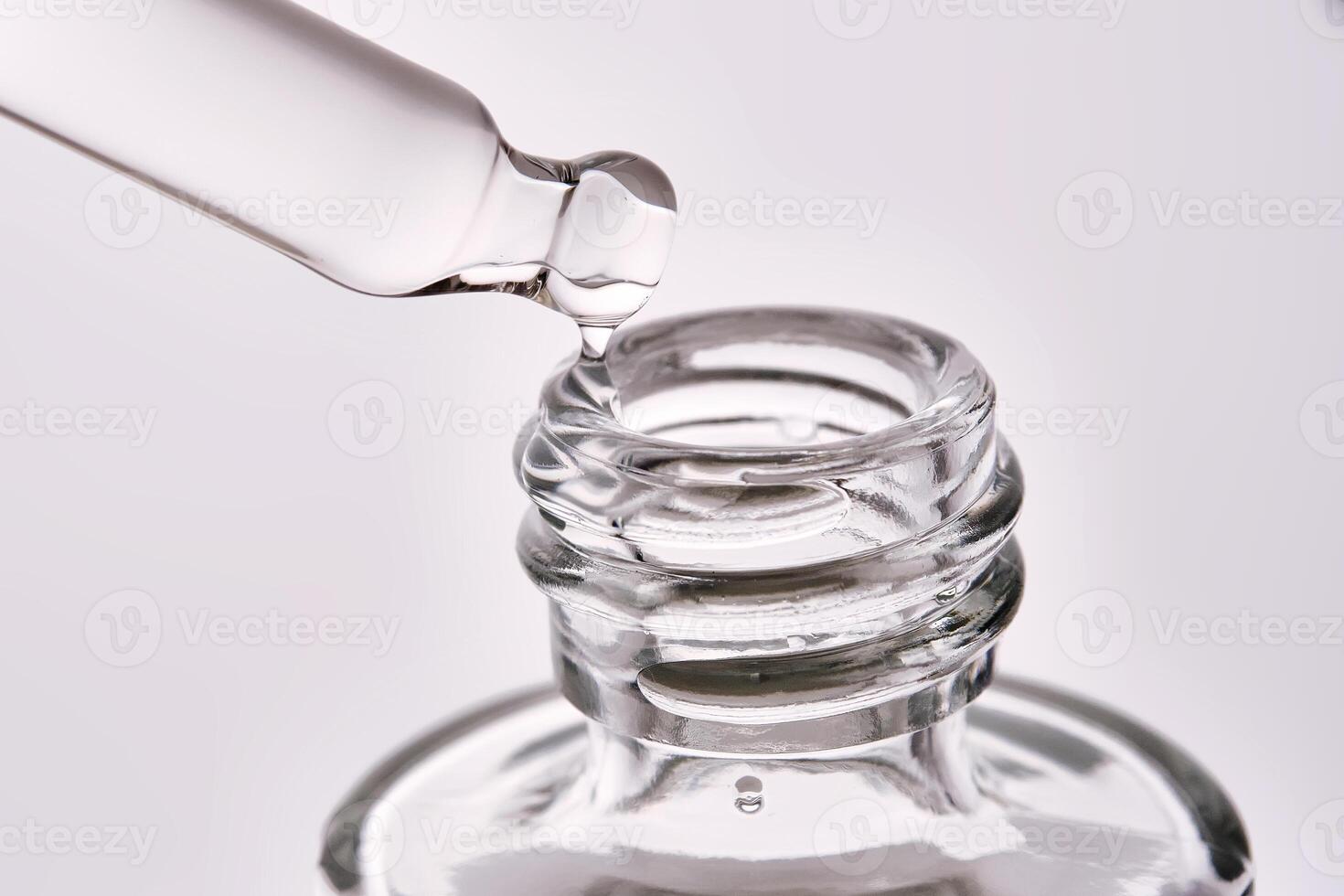 Cosmetic bottle with a pipette showing the texture of the serum. photo