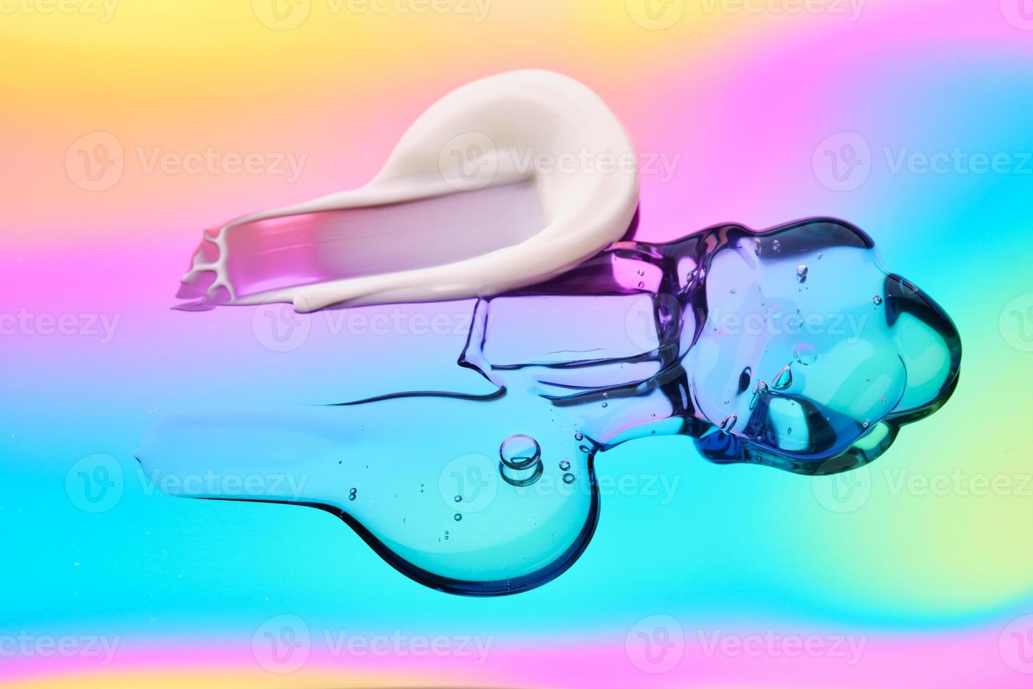 A drop of cosmetic serum, cream and gel on a multicolored background in shades of blue and lilac. photo