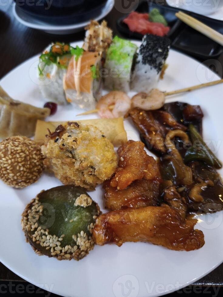 Delicious asian food buffet displaying variety of dishes including sushi, spring rolls and sesame balls all you can eat photo
