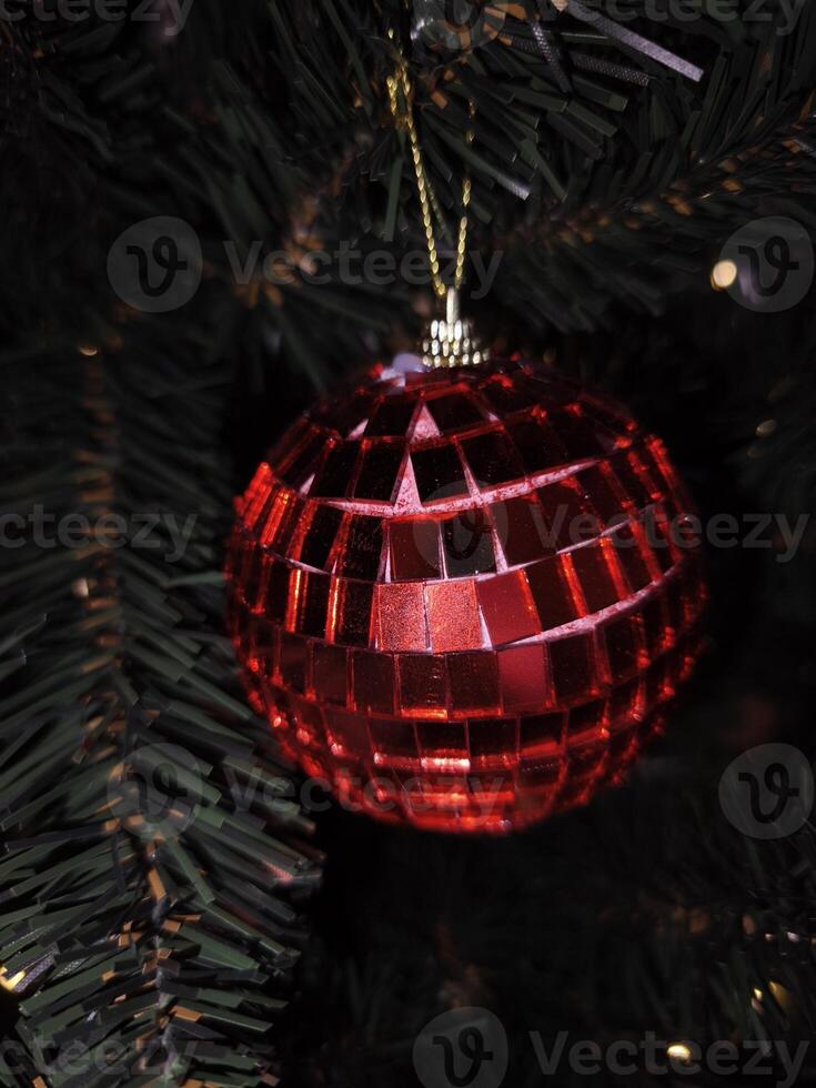 Red disco ball ornament hanging on christmas tree in prague photo