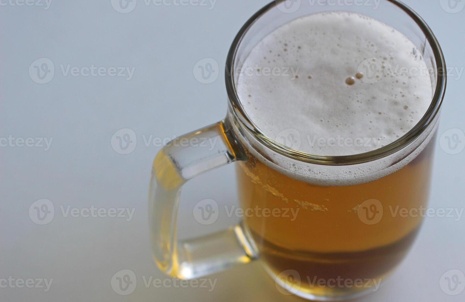 Rich color of indian pale ale in a classic beer glass on white surface top view. Foam On Pale Ale In A Beer Mug Extreme Closeup Stock Photo
