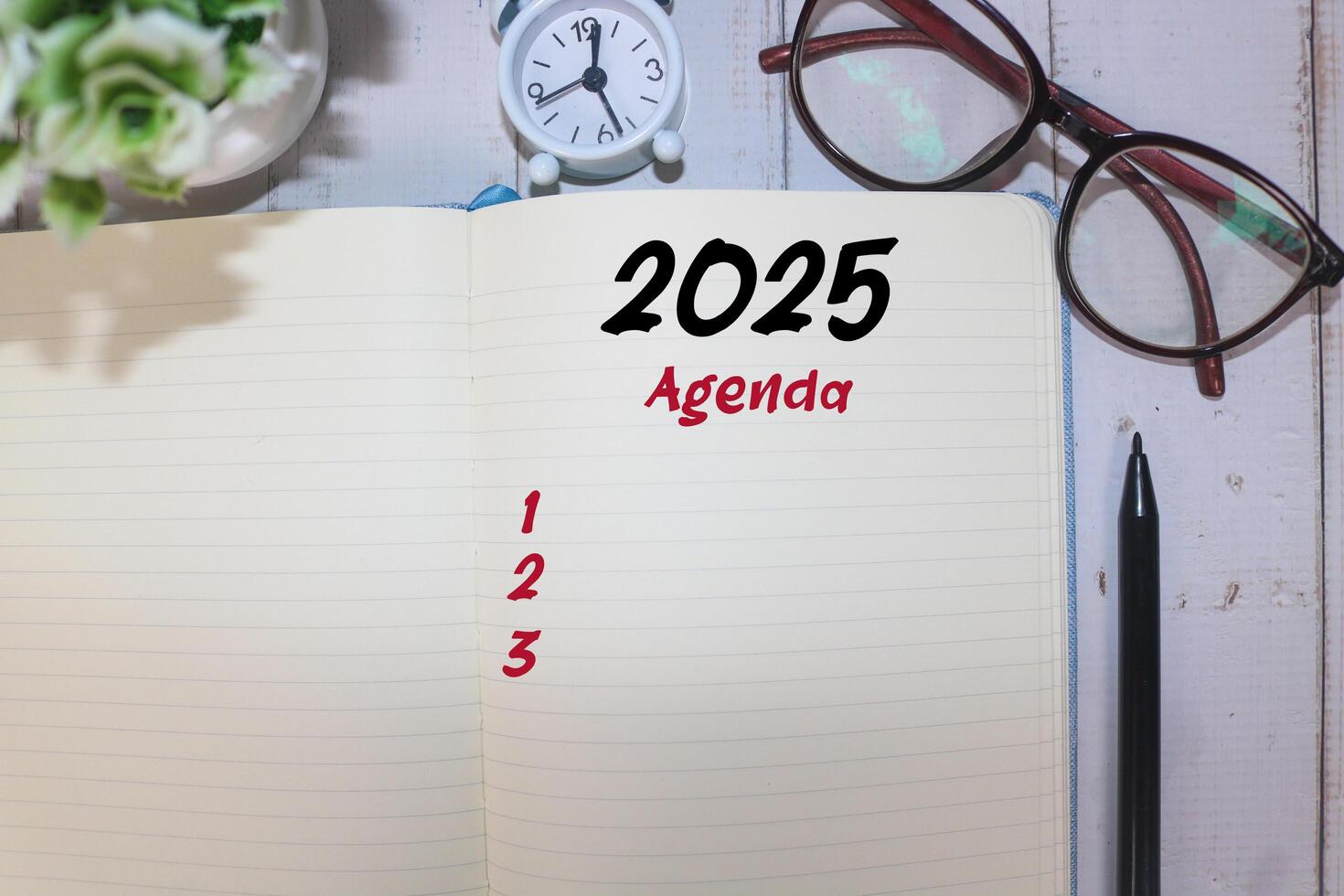 2025 New Year resolutions goals, plans, and resolutions concept. Planning checklist 2025 target on notebook with office desk background. 2025 agenda in notebook on table photo