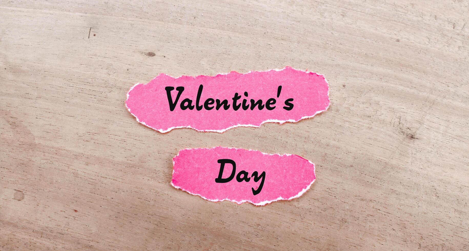 Valentine's Day words on pink torn paper. Valentine's day concept photo
