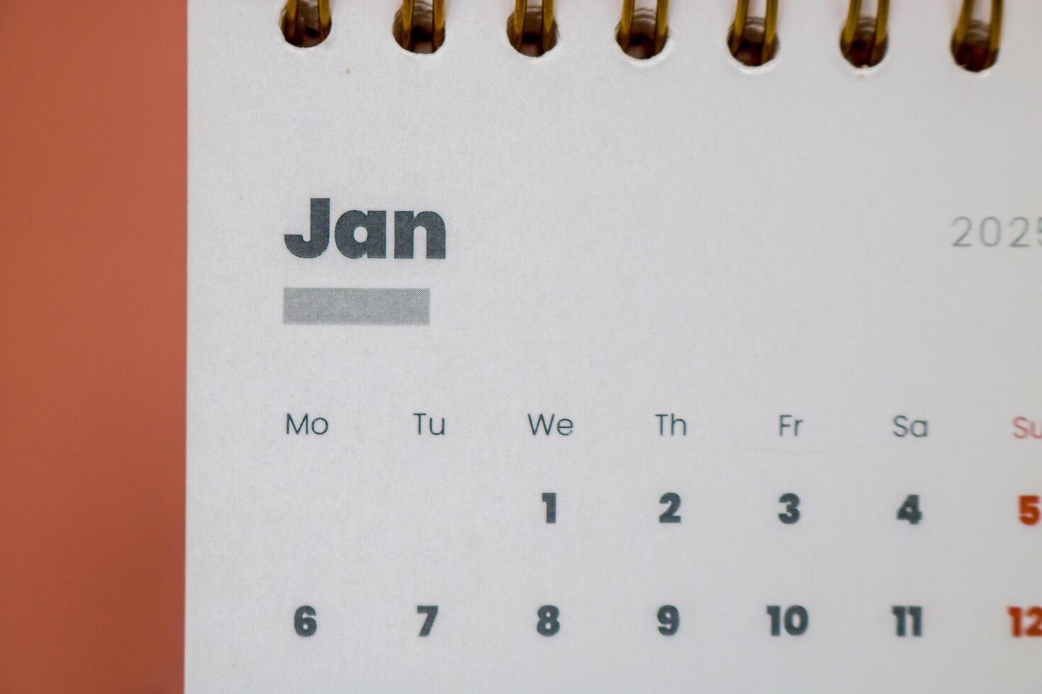Close up of January month of the beginning of the year 2025 in the 2025 calendar in pink isolated on a pink background. Calendar and Note Pad Happy New year 2025. photo