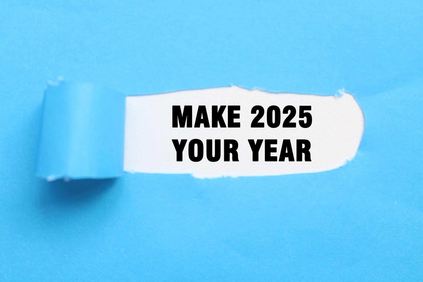Make 2025 your year on blue torn paper. Plans for the new year 2025. Commercial year 2025 photo