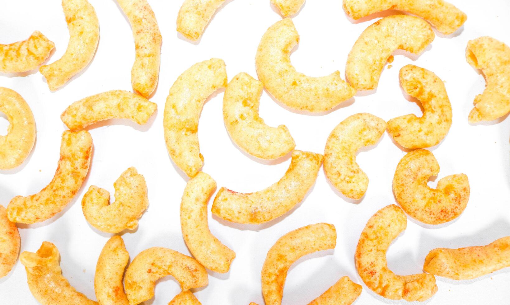 A collection of white fried macaroni scattered isolated on white background. Savory fried macaroni in Indonesia photo